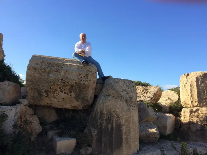 Arnold Stadler sitzt auf Felsen.