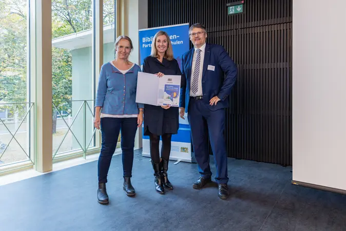 Kultusministerin Anna Stolz (Mitte) überreichte Christiane Lauterbach und Fabian Franke von der Bamberger Universitätsbibliothek das Gütesiegel „Bibliotheken – Partner der Schulen“.