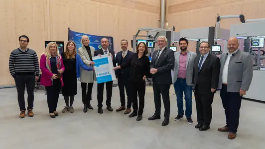 Hubert Awanger übergibt einen Förderbescheid über 1,5 Millionen Euro an die Universität Bamberg zur Fortsetzung des KMU-KI-Erfahrungszentrums. Das Bild zeigt den Minister mit Vertretern der Universität sowie aus der Landes- und Kommunalpolitik.