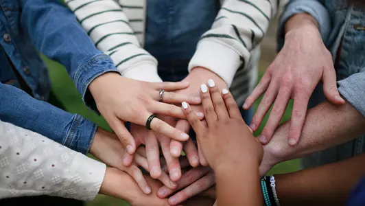 Close-up of diverse group of friends stacking their hands together in circle, Friendship and lifestyle concepts Close-up of diverse group of friends stacking their hands together in circle, Friendship and lifestyle concepts