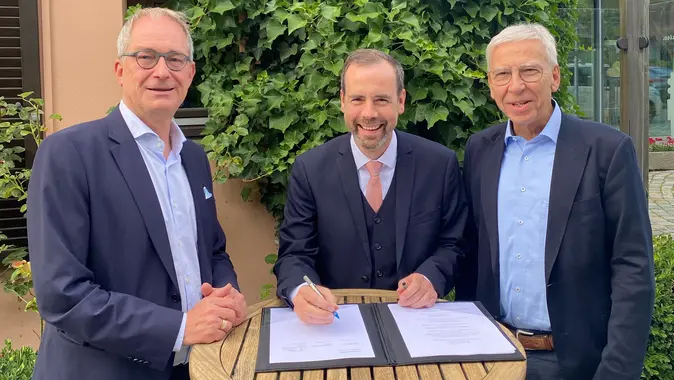 Universitätspräsident Kai Fischbach (Mitte) unterzeichnet den Kooperationsvertrag. Mit ihm auf dem Bild die Präsidenten der Universitäten Bayreuth und Regensburg, Prof. Dr. Stefan Leible (l.) und Prof. Dr. Udo Hebel (r.).